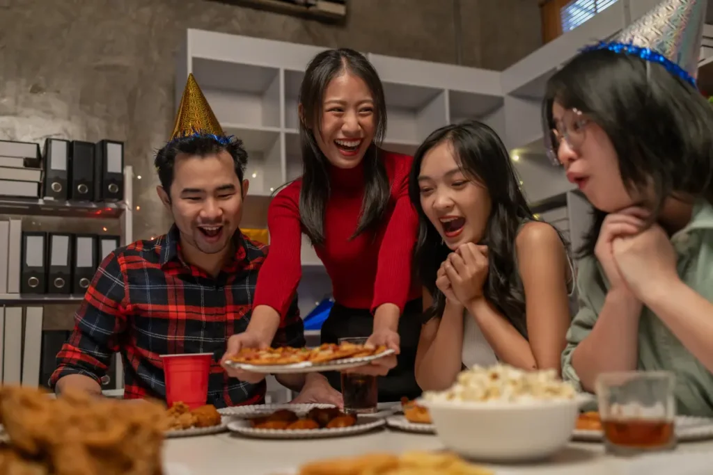Friends enjoying pizza takeaway together at a relaxed indoor party