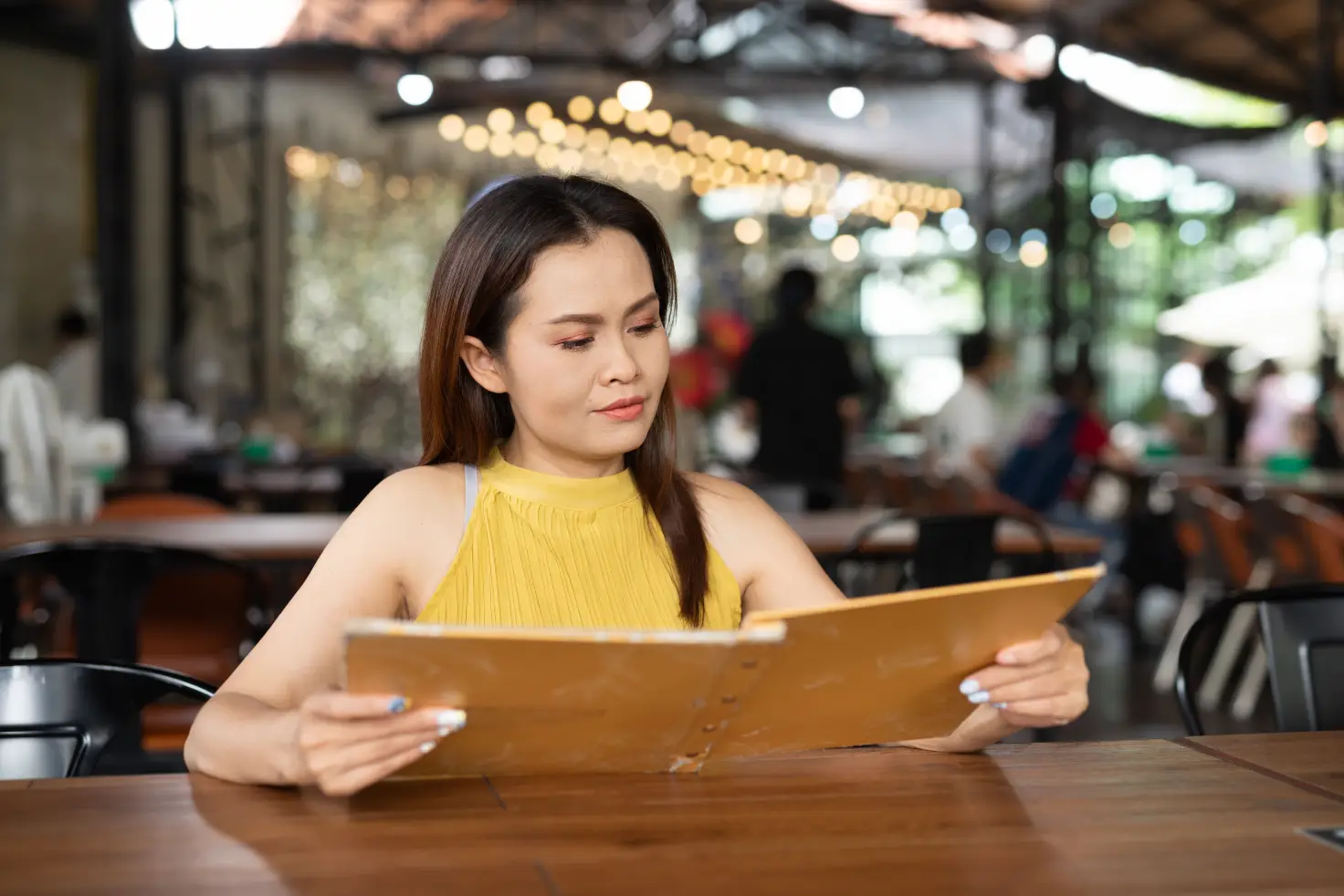 Diner reviewing a pizza menu while seated at a casual restaurant